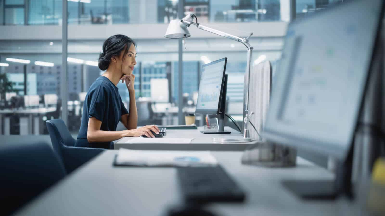 Eine Frau im Büro am Computer analysiert die Konkurrenz online.