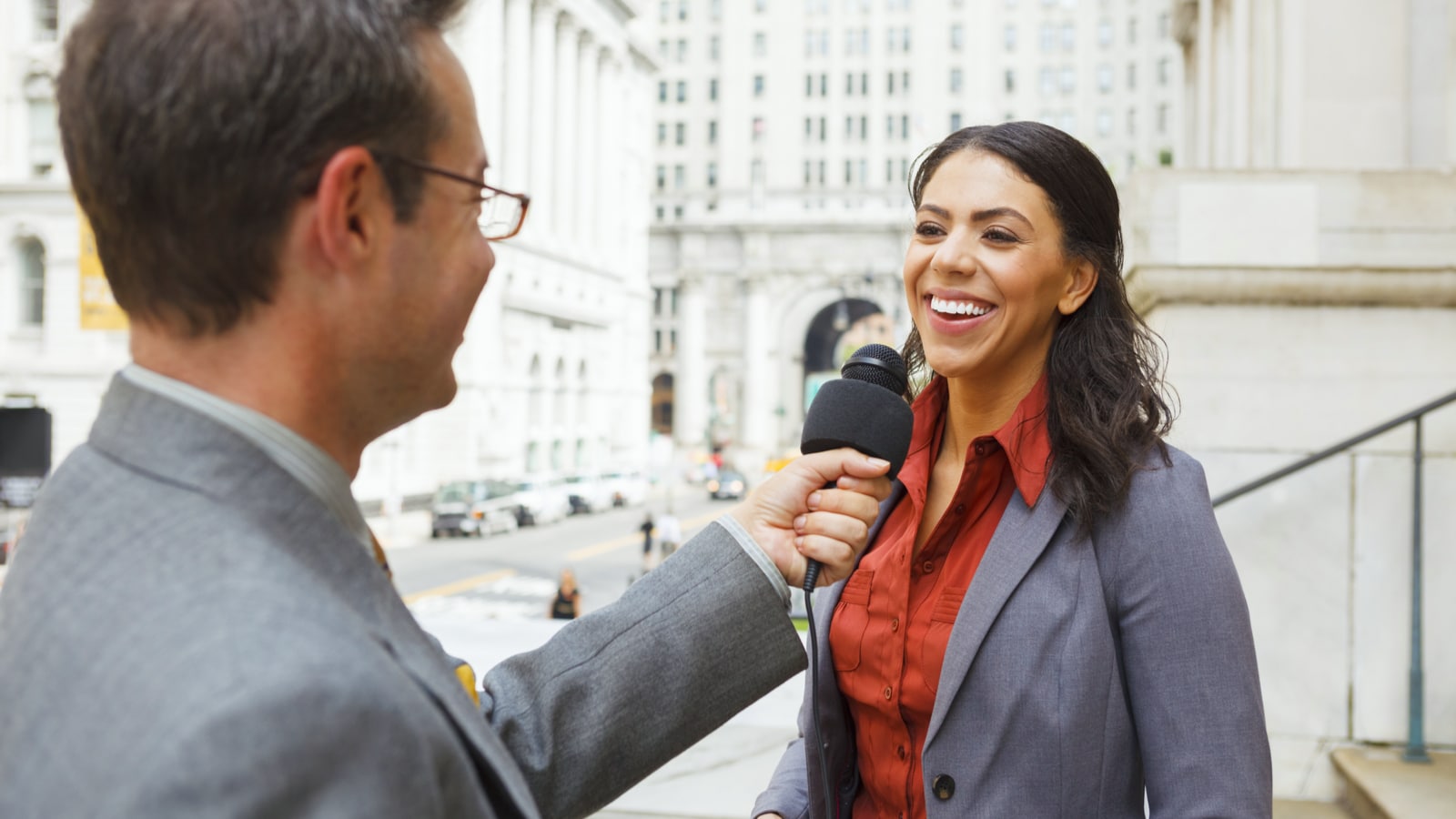 Eine Mediensprecherin wird von einem Mann mit Mikrofon interviewt.