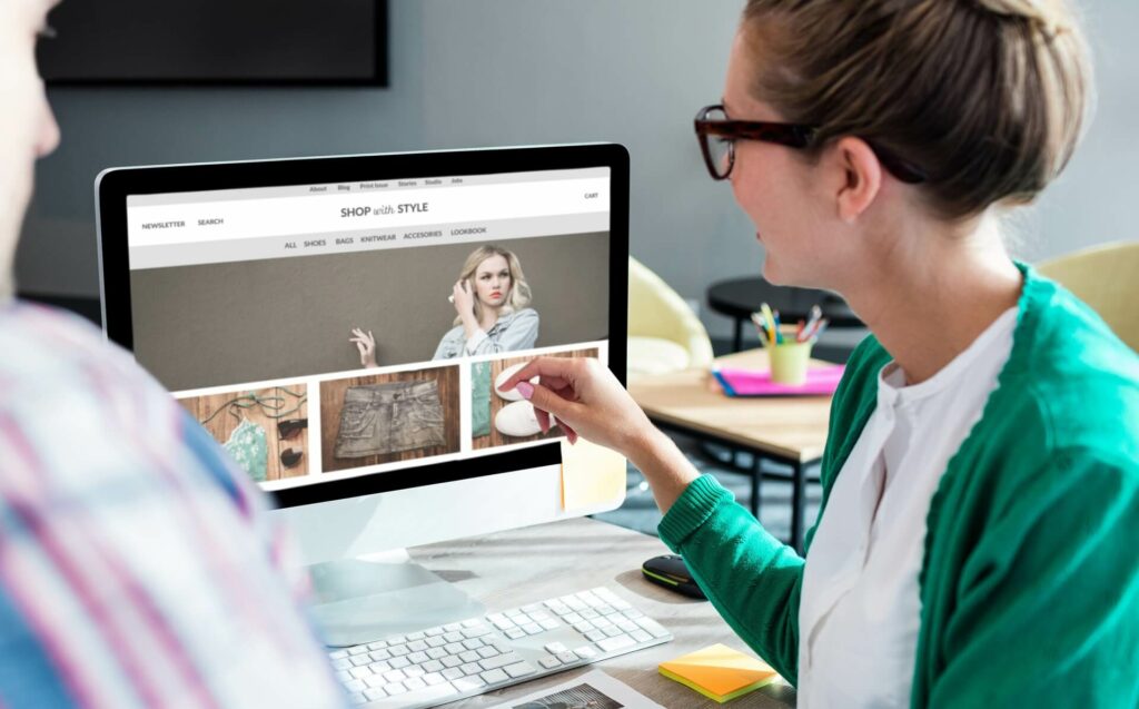 Eine Frau zeigt einen Onlineshop auf Ihrem Computerbildschirm.