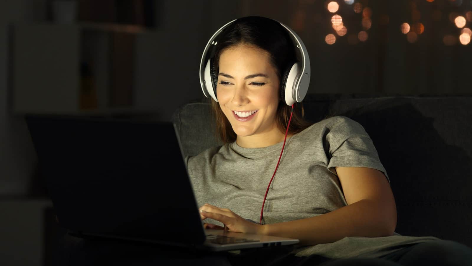 Junge Frau schaut Netflix auf dem Laptop, da Streamingdienste an Popularität gewinnen