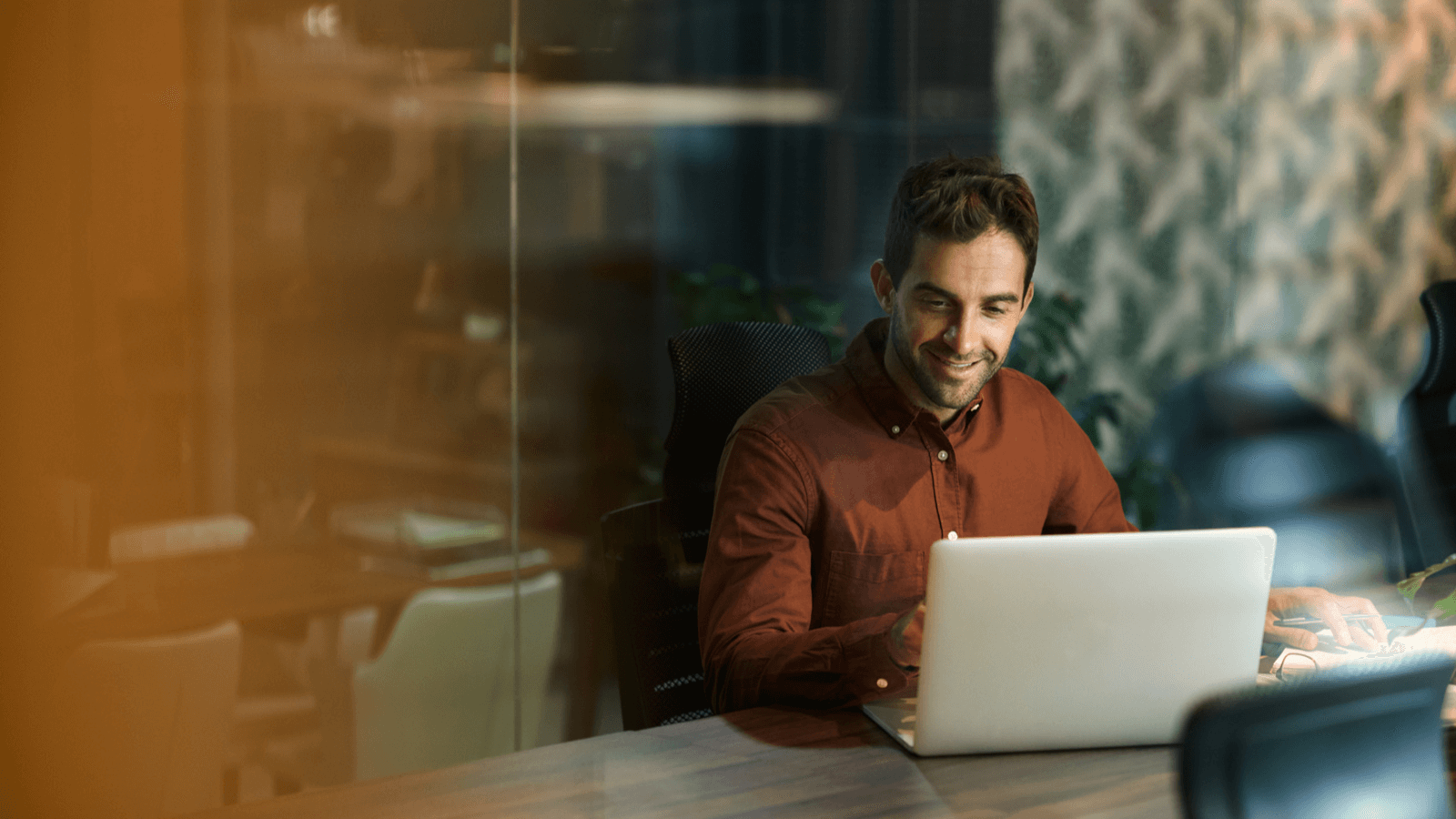 Ein Mann sitzt vor dem Laptop und arbeitet für sein B2B-Unternehmen.
