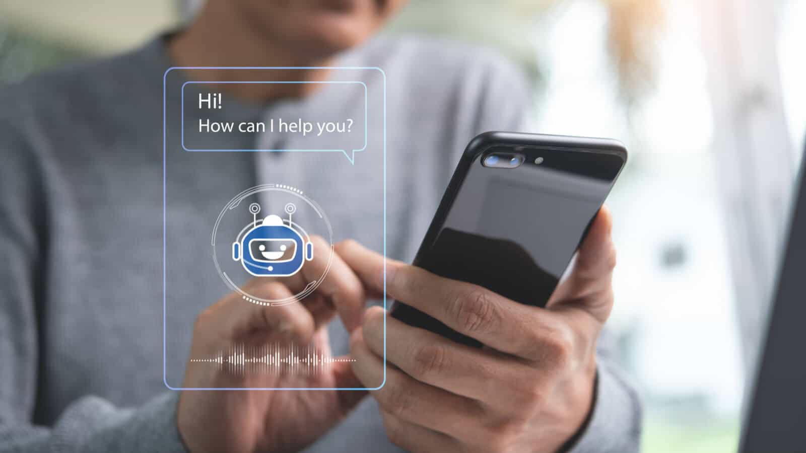 Mann am Smartphone schreibt mit einem Chatbot, der ihm seine Fragen beantworten soll