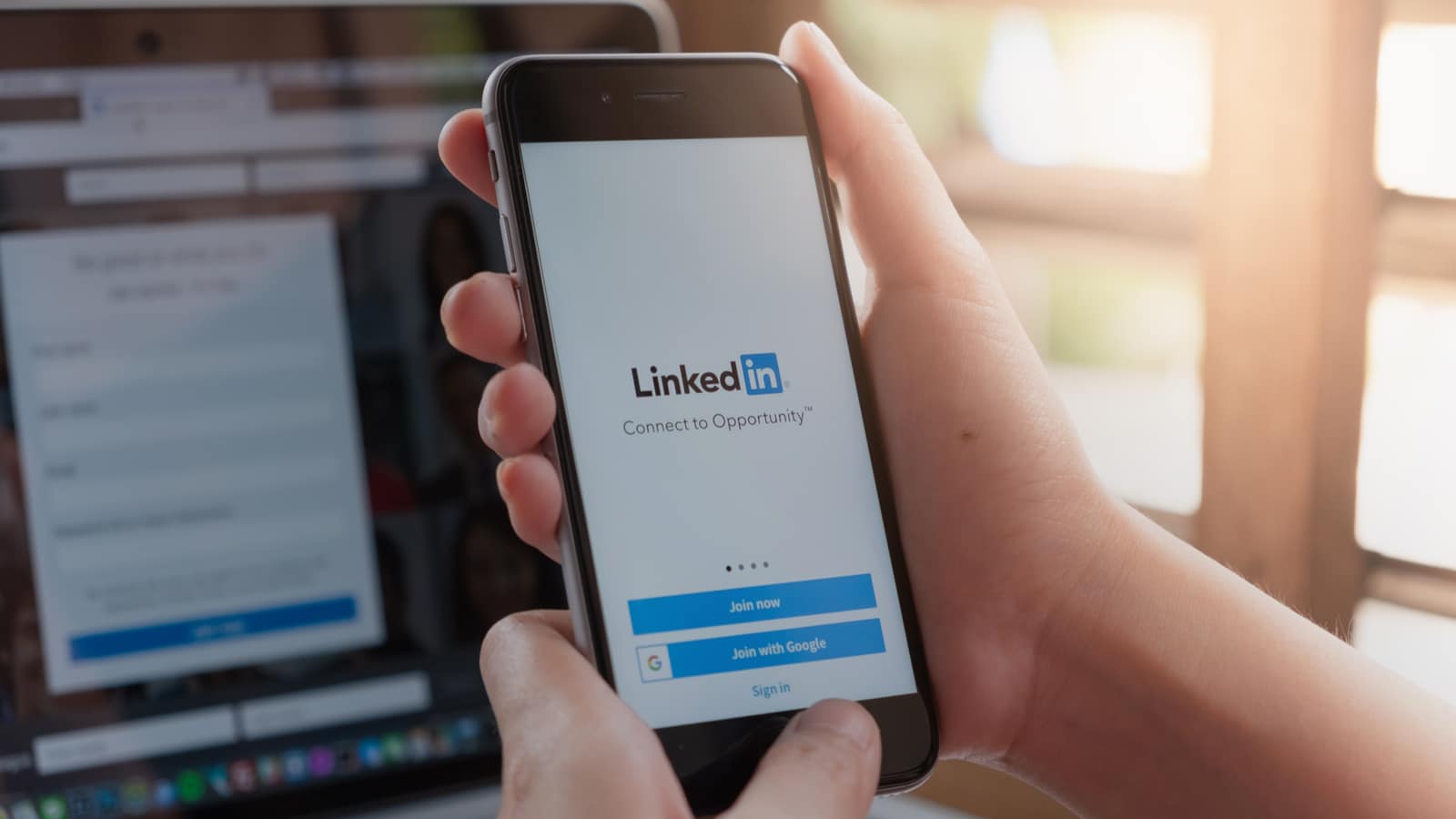 Person nutzt LinkedIn, wo bald auch Story Ads erstellt werden können, auf dem Smartphone