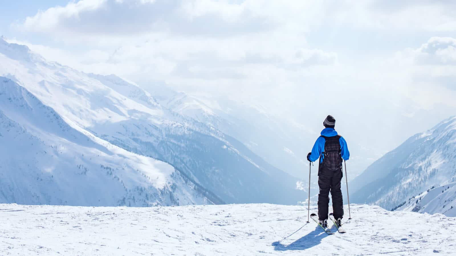 Skifahrer steht vor Bergkulisse in der Schweiz wegen Tourismus Kampagne