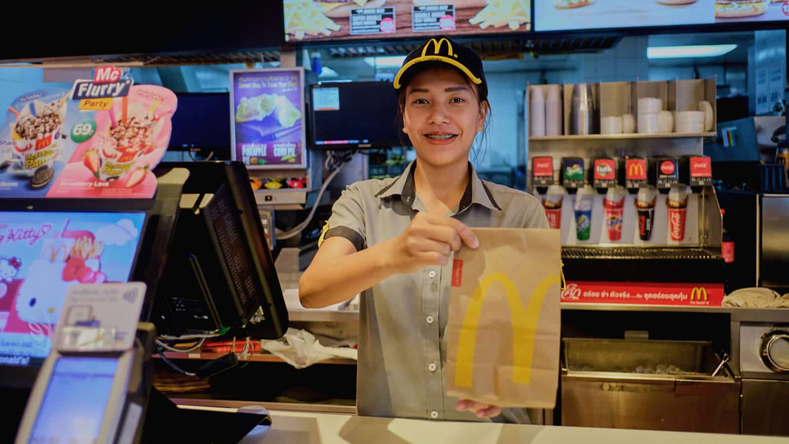 McDonalds Mitarbeiter an Theke und wird zu Weihnachten überrascht