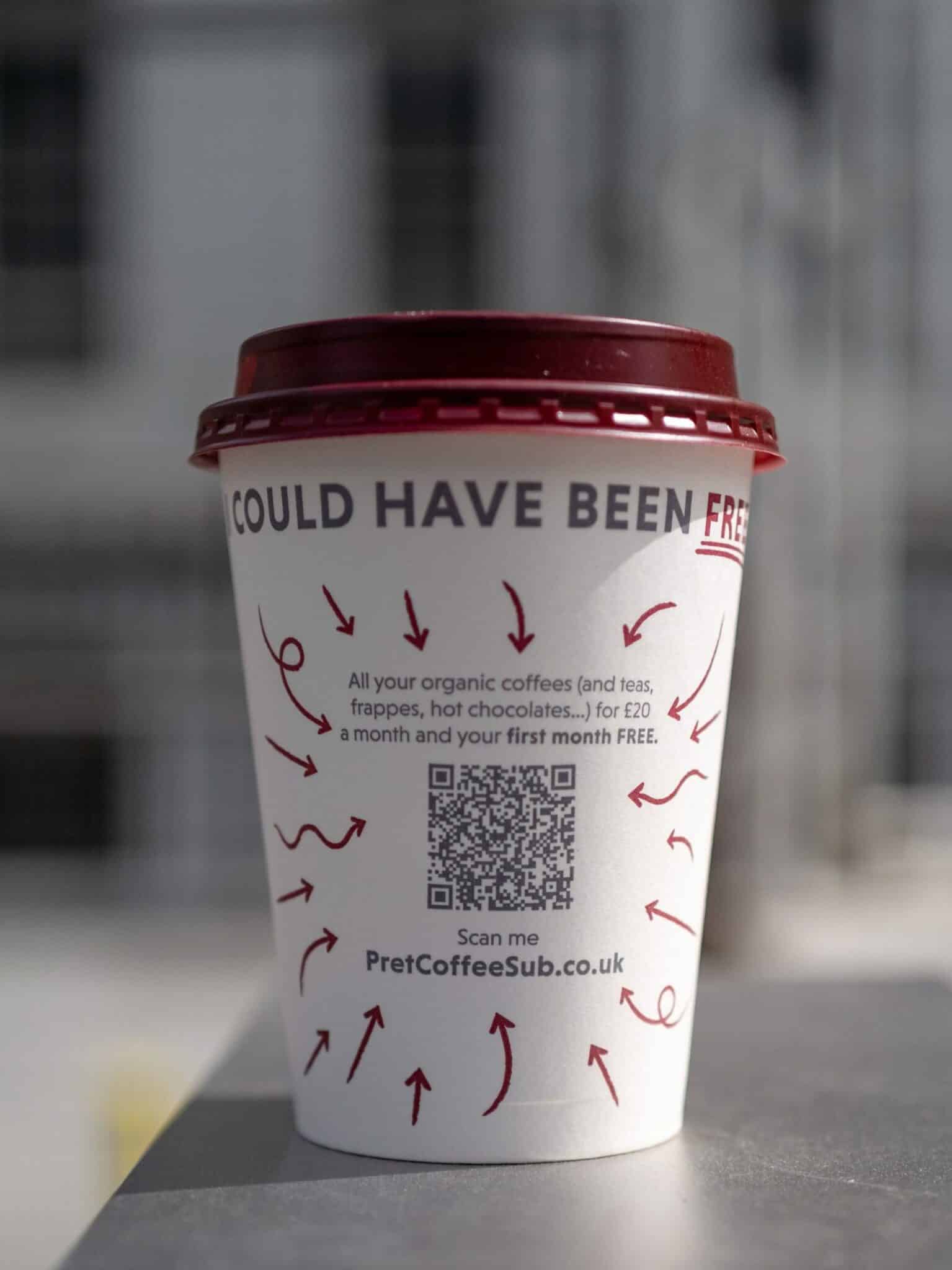 Ein Kaffeebecher mit einem QR-Code zum scannen darauf.
