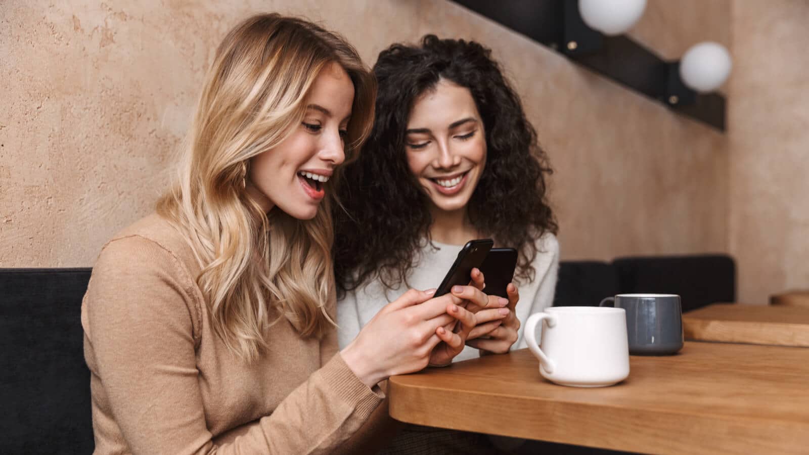 Zwei Frauen am Smartphone auf Instagram, wo neu Guides erstellt werden können