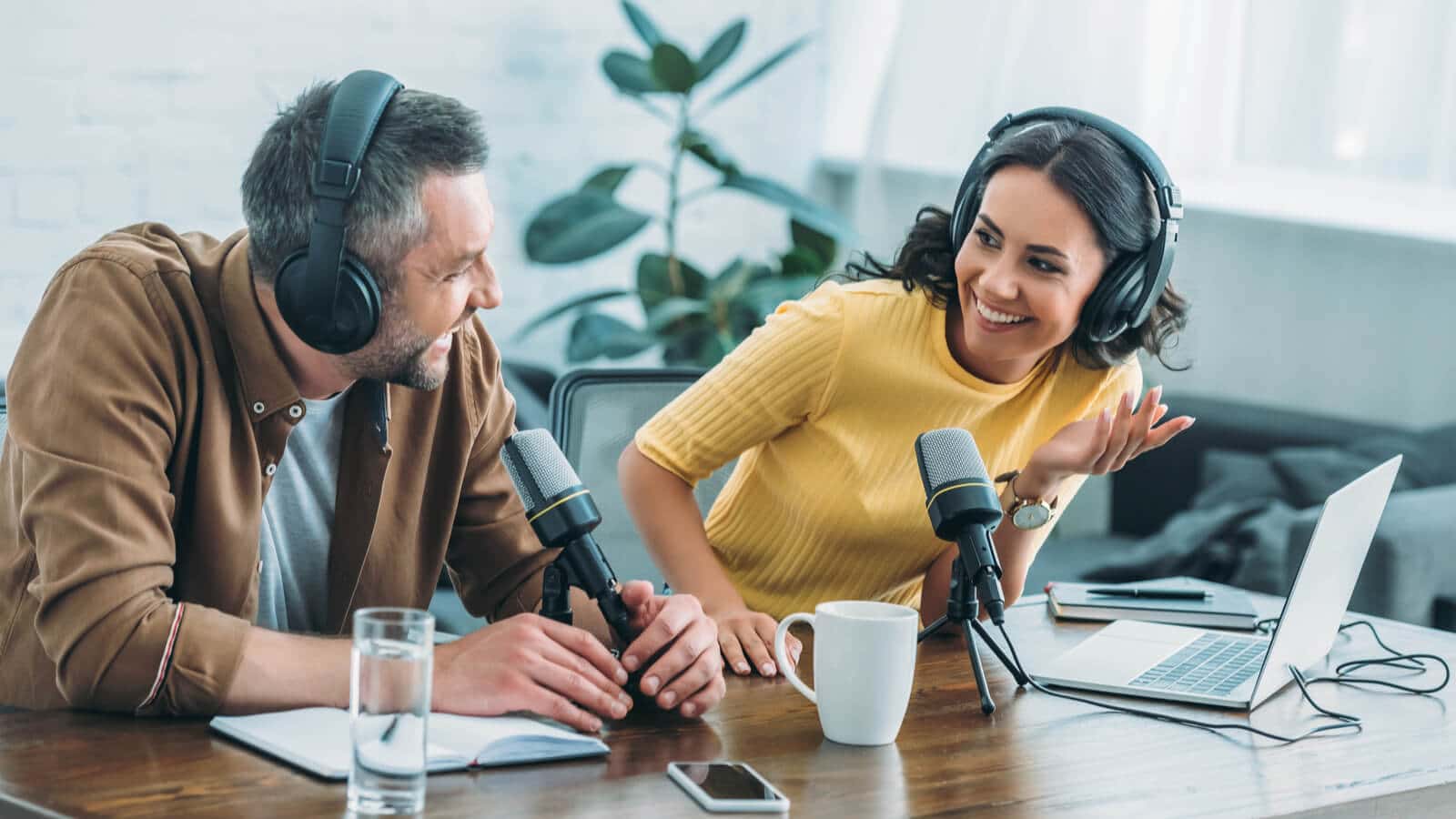 Zwei Unternehmer vor Mikrofonen nehmen als Marketing Massnahme einen Podcast auf