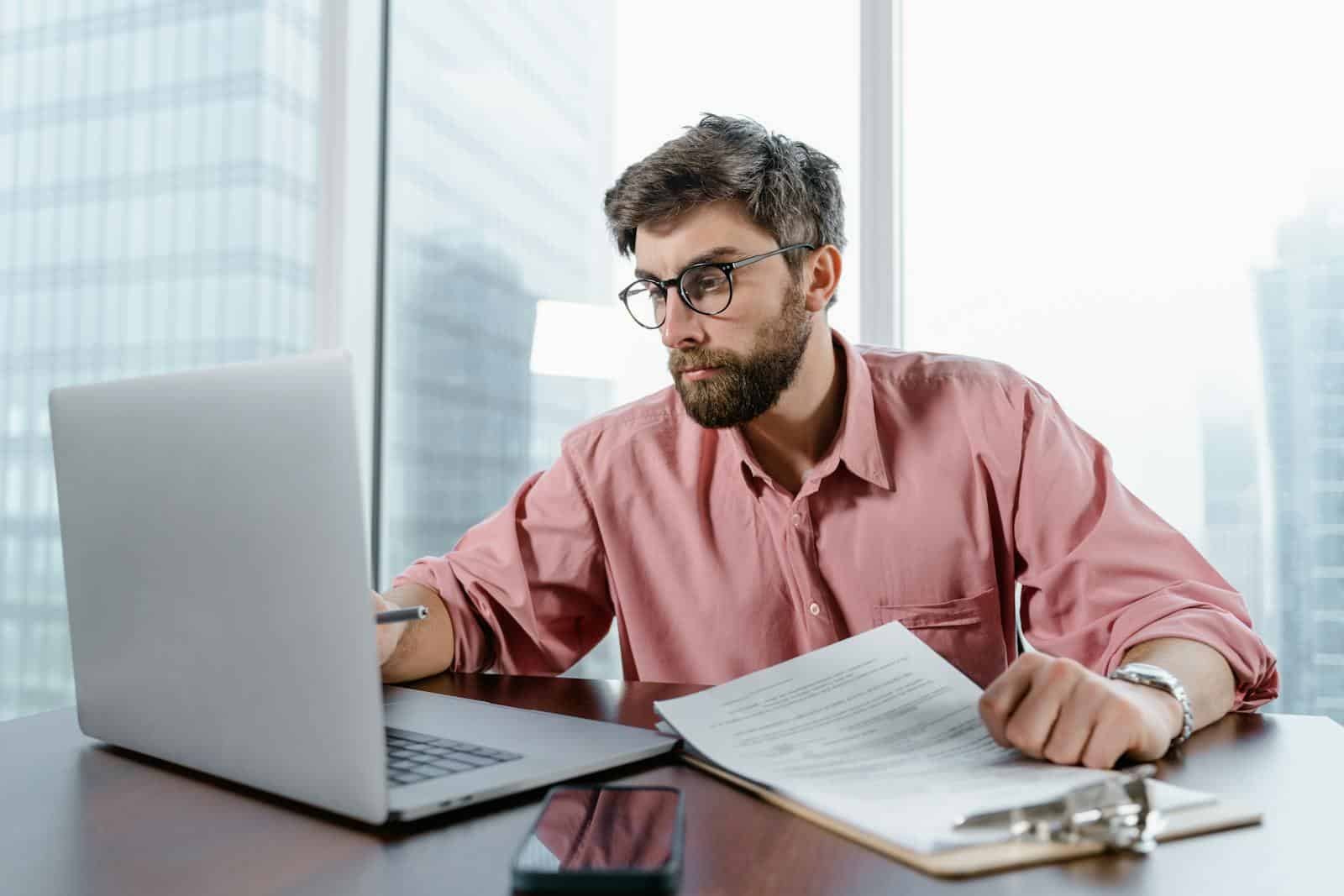 Ein Mann mit Brille sitzt an einem Laptop.